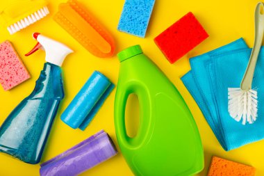 Temizlik hizmeti konsepti. Sarı arka planda ev temizlik ürünü. Evdeki kimyasallarla dolu bir kova. Ev ve ofis için temizlik malzemeleri. Erken bahar düzenli temizlik. Boşluğu kopyala