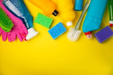 Temizlik hizmeti konsepti. Sarı arka planda ev temizlik ürünü. Evdeki kimyasallarla dolu bir kova. Ev ve ofis için temizlik malzemeleri. Erken bahar düzenli temizlik. Boşluğu kopyala