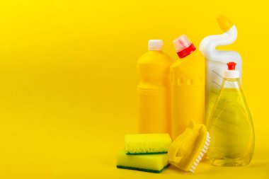 Temizlik hizmeti konsepti. Sarı arka planda ev temizlik ürünü. Evdeki kimyasallarla dolu bir kova. Ev ve ofis için temizlik malzemeleri. Erken bahar düzenli temizlik. Boşluğu kopyala
