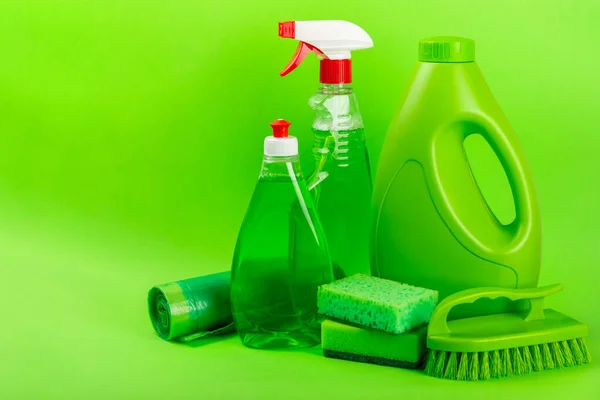 Cleaning service concept.Home cleaning product on a green background. Bucket with household chemicals. cleaning supplies for home or office space.Early spring regular cleaning. Copy space