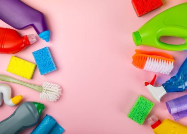 Temizlik hizmeti konsepti. Pembe arka planda ev temizlik ürünü. Evdeki kimyasallarla dolu bir kova. Ev ve ofis için temizlik malzemeleri. Erken bahar düzenli temizlik. Boşluğu kopyala