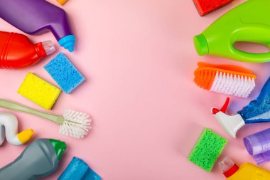 Temizlik hizmeti konsepti. Pembe arka planda ev temizlik ürünü. Evdeki kimyasallarla dolu bir kova. Ev ve ofis için temizlik malzemeleri. Erken bahar düzenli temizlik. Boşluğu kopyala