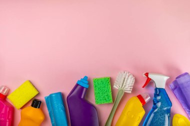 Temizlik hizmeti konsepti. Pembe arka planda ev temizlik ürünü. Evdeki kimyasallarla dolu bir kova. Ev ve ofis için temizlik malzemeleri. Erken bahar düzenli temizlik. Boşluğu kopyala