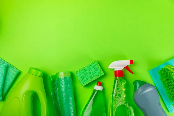 Cleaning service concept.Home cleaning product on a green background. Bucket with household chemicals. cleaning supplies for home or office space.Early spring regular cleaning. Copy space