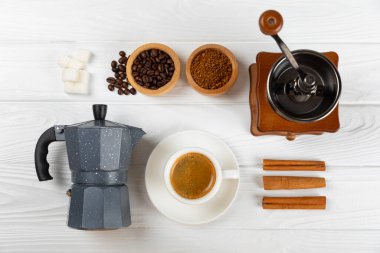 Kahve yapmak için gerekli malzemeler. Moka demliği, Türk kahve demliği (cezve), kahve çekirdeği, süt, şeker ve baharatlı kahve öğütücü beyaz arka planda. İçki hazırlama konsepti. Düz Katman. Boşluğu kopyala.