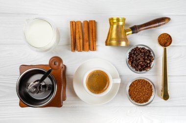 Kahve yapmak için gerekli malzemeler. Moka demliği, Türk kahve demliği (cezve), kahve çekirdeği, süt, şeker ve baharatlı kahve öğütücü beyaz arka planda. İçki hazırlama konsepti. Düz Katman. Boşluğu kopyala.