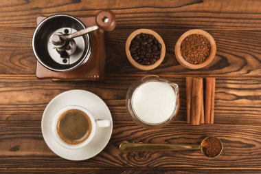 Kahve yapmak için gerekli malzemeler. Kahverengi zemin üzerinde kahve çekirdeği, süt, şeker ve baharat bulunan kahve makinası. İçki hazırlama konsepti. Düz Katman. Boşluğu kopyala.