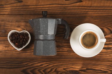 Kahve yapmak için gerekli malzemeler. Kahverengi zemin üzerinde kahve çekirdeği, süt, şeker ve baharat bulunan kahve makinası. İçki hazırlama konsepti. Düz Katman. Boşluğu kopyala.