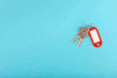 Farklı renklerde plastik anahtarlık ve parlak renkli arka planda imza için bir yer. Anahtarlığı olan bir sürü anahtar. Model anahtarlık. Kopya alanı. Emlak kiralama ve satma kavramı..