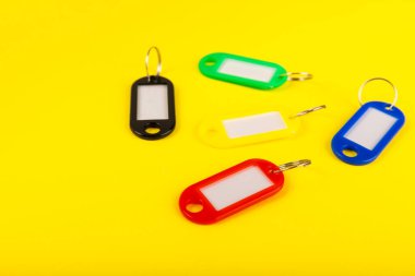 Farklı renklerde plastik anahtarlık ve parlak renkli arka planda imza için bir yer. Anahtarlığı olan bir sürü anahtar. Model anahtarlık. Kopya alanı. Emlak kiralama ve satma kavramı..
