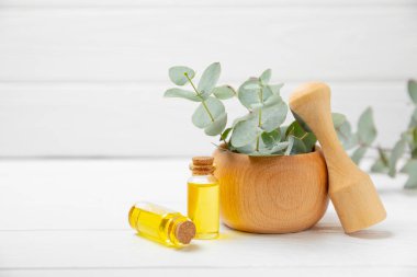 Tahta zeminde okaliptüs yaprakları ve harç. Alternatif tıp ve doğal kozmetik ürünleri için spa konsepti. Bir şişe gerekli yağ ve bir demet okaliptüs. Organik cilt bakımı 