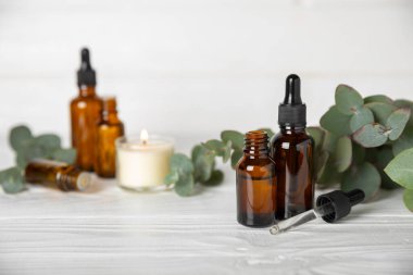 Okaliptüs, ahşap kaplamalı yeşil okaliptüs yapraklı cam bir şişede gerekli yağdır. Aromaterapi konsepti. Spa mı? Kozmetik ve vücut bakımı için doğal organik malzemeler.