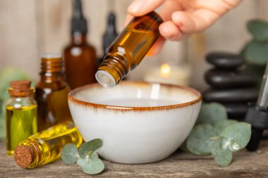 Okaliptüs, ahşap kaplamalı yeşil okaliptüs yapraklı cam bir şişede gerekli yağdır. Aromaterapi konsepti. Spa mı? Kozmetik ve vücut bakımı için doğal organik malzemeler.