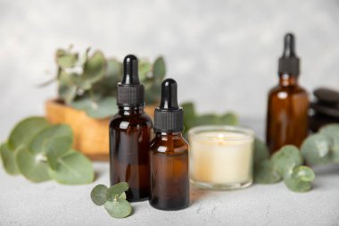 Okaliptüs, ahşap kaplamalı yeşil okaliptüs yapraklı cam bir şişede gerekli yağdır. Aromaterapi konsepti. Spa mı? Kozmetik ve vücut bakımı için doğal organik malzemeler.