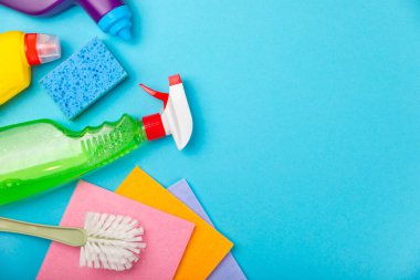 Temizlik hizmeti konsepti. Mavi arka planda ev temizlik ürünü. Evdeki kimyasallarla dolu bir kova. Ev ve ofis için temizlik malzemeleri. Erken bahar düzenli temizlik. Boşluğu kopyala