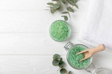 Kozmetik deniz tuzu aromalı ve okaliptüs özlü taze aromatik okaliptüs dallı ahşap bir arkaplan. Spa konsepti. Banyo tuzu. Yakın plan. Metin için boşluk. Vücut bakımı. Boşluğu kopyala