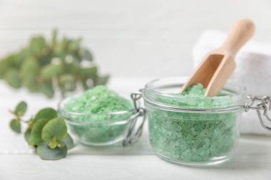 Kozmetik deniz tuzu aromalı ve okaliptüs özlü taze aromatik okaliptüs dallı ahşap bir arkaplan. Spa konsepti. Banyo tuzu. Yakın plan. Metin için boşluk. Vücut bakımı. Boşluğu kopyala