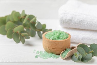 Kozmetik deniz tuzu aromalı ve okaliptüs özlü taze aromatik okaliptüs dallı ahşap bir arkaplan. Spa konsepti. Banyo tuzu. Yakın plan. Metin için boşluk. Vücut bakımı. Boşluğu kopyala