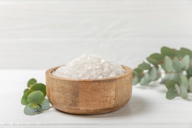 Kozmetik deniz tuzu aromalı ve okaliptüs özlü taze aromatik okaliptüs dallı ahşap bir arkaplan. Spa konsepti. Banyo tuzu. Yakın plan. Metin için boşluk. Vücut bakımı. Boşluğu kopyala