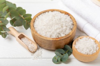 Kozmetik deniz tuzu aromalı ve okaliptüs özlü taze aromatik okaliptüs dallı ahşap bir arkaplan. Spa konsepti. Banyo tuzu. Yakın plan. Metin için boşluk. Vücut bakımı. Boşluğu kopyala