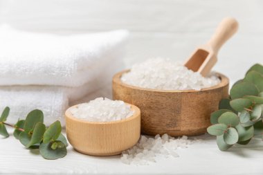 Kozmetik deniz tuzu aromalı ve okaliptüs özlü taze aromatik okaliptüs dallı ahşap bir arkaplan. Spa konsepti. Banyo tuzu. Yakın plan. Metin için boşluk. Vücut bakımı. Boşluğu kopyala