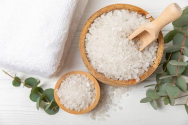 Kozmetik deniz tuzu aromalı ve okaliptüs özlü taze aromatik okaliptüs dallı ahşap bir arkaplan. Spa konsepti. Banyo tuzu. Yakın plan. Metin için boşluk. Vücut bakımı. Boşluğu kopyala
