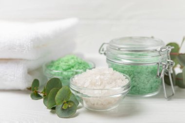 Kozmetik deniz tuzu aromalı ve okaliptüs özlü taze aromatik okaliptüs dallı ahşap bir arkaplan. Spa konsepti. Banyo tuzu. Yakın plan. Metin için boşluk. Vücut bakımı. Boşluğu kopyala
