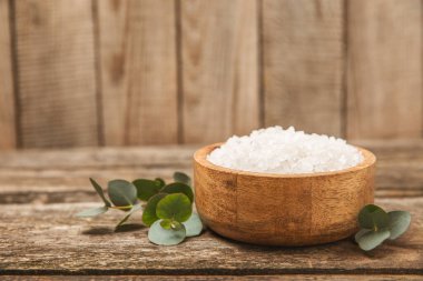 Kozmetik deniz tuzu aromalı ve okaliptüs özlü taze aromatik okaliptüs dallı ahşap bir arkaplan. Spa konsepti. Banyo tuzu. Yakın plan. Metin için boşluk. Vücut bakımı. Boşluğu kopyala