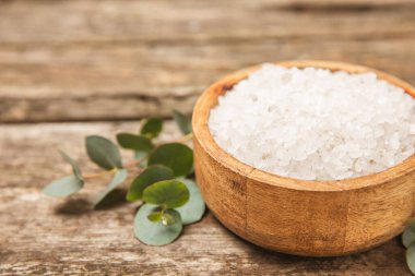 Kozmetik deniz tuzu aromalı ve okaliptüs özlü taze aromatik okaliptüs dallı ahşap bir arkaplan. Spa konsepti. Banyo tuzu. Yakın plan. Metin için boşluk. Vücut bakımı. Boşluğu kopyala