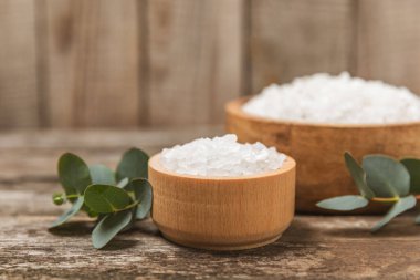 Kozmetik deniz tuzu aromalı ve okaliptüs özlü taze aromatik okaliptüs dallı ahşap bir arkaplan. Spa konsepti. Banyo tuzu. Yakın plan. Metin için boşluk. Vücut bakımı. Boşluğu kopyala