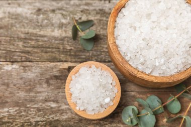 Kozmetik deniz tuzu aromalı ve okaliptüs özlü taze aromatik okaliptüs dallı ahşap bir arkaplan. Spa konsepti. Banyo tuzu. Yakın plan. Metin için boşluk. Vücut bakımı. Boşluğu kopyala