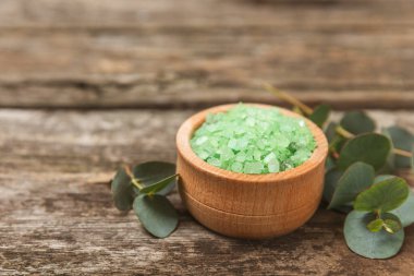 Kozmetik deniz tuzu aromalı ve okaliptüs özlü taze aromatik okaliptüs dallı ahşap bir arkaplan. Spa konsepti. Banyo tuzu. Yakın plan. Metin için boşluk. Vücut bakımı. Boşluğu kopyala