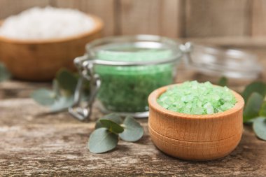 Kozmetik deniz tuzu aromalı ve okaliptüs özlü taze aromatik okaliptüs dallı ahşap bir arkaplan. Spa konsepti. Banyo tuzu. Yakın plan. Metin için boşluk. Vücut bakımı. Boşluğu kopyala