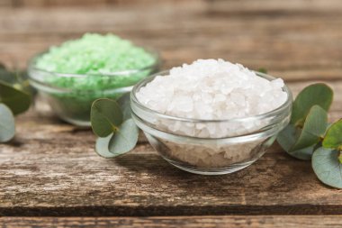 Kozmetik deniz tuzu aromalı ve okaliptüs özlü taze aromatik okaliptüs dallı ahşap bir arkaplan. Spa konsepti. Banyo tuzu. Yakın plan. Metin için boşluk. Vücut bakımı. Boşluğu kopyala