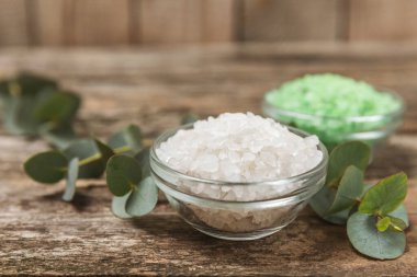Kozmetik deniz tuzu aromalı ve okaliptüs özlü taze aromatik okaliptüs dallı ahşap bir arkaplan. Spa konsepti. Banyo tuzu. Yakın plan. Metin için boşluk. Vücut bakımı. Boşluğu kopyala