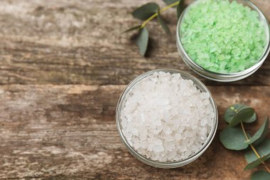 Kozmetik deniz tuzu aromalı ve okaliptüs özlü taze aromatik okaliptüs dallı ahşap bir arkaplan. Spa konsepti. Banyo tuzu. Yakın plan. Metin için boşluk. Vücut bakımı. Boşluğu kopyala
