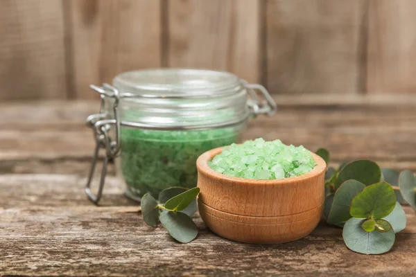 Kozmetik deniz tuzu aromalı ve okaliptüs özlü taze aromatik okaliptüs dallı ahşap bir arkaplan. Spa konsepti. Banyo tuzu. Yakın plan. Metin için boşluk. Vücut bakımı. Boşluğu kopyala