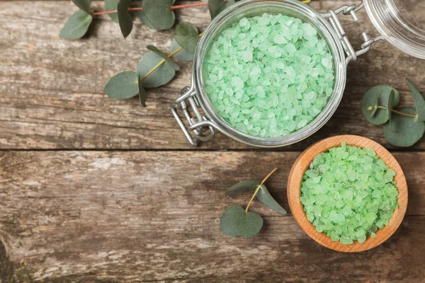 Kozmetik deniz tuzu aromalı ve okaliptüs özlü taze aromatik okaliptüs dallı ahşap bir arkaplan. Spa konsepti. Banyo tuzu. Yakın plan. Metin için boşluk. Vücut bakımı. Boşluğu kopyala