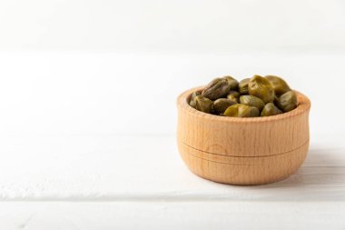 Ahşap mutfak masasında kapari. Deniz tuzu ve biberiyeli kapari. Turşu turşusu. Akdeniz mutfağı malzemesi. Organik baharatlar ve baharatlar. Boşluğu kopyala.