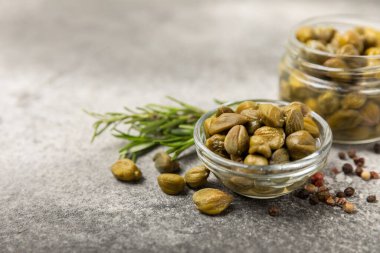Ahşap mutfak masasında kapari. Deniz tuzu ve biberiyeli kapari. Turşu turşusu. Akdeniz mutfağı malzemesi. Organik baharatlar ve baharatlar. Boşluğu kopyala.