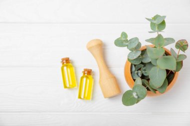 Tahta zeminde okaliptüs yaprakları ve harç. Alternatif tıp ve doğal kozmetik ürünleri için spa konsepti. Bir şişe gerekli yağ ve bir demet okaliptüs. Organik cilt bakımı 