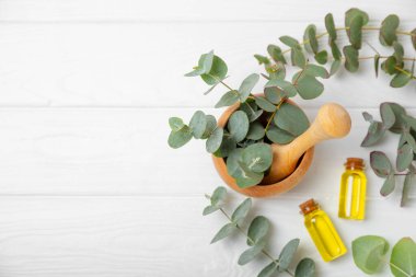 Tahta zeminde okaliptüs yaprakları ve harç. Alternatif tıp ve doğal kozmetik ürünleri için spa konsepti. Bir şişe gerekli yağ ve bir demet okaliptüs. Organik cilt bakımı 