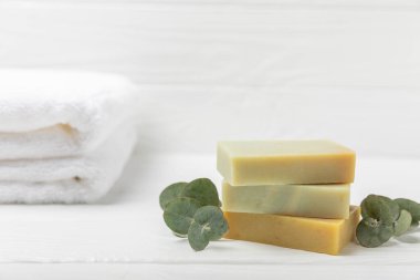 Arkaplanda sabun var. Okaliptüs özlü sabun ve beyaz arka planda doğal otlar. Güzel Doğal sabun kalıpları. El yapımı organik sabun konsepti. Cilt bakımı. Pankart
