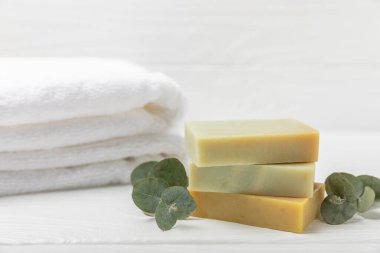 Arkaplanda sabun var. Okaliptüs özlü sabun ve beyaz arka planda doğal otlar. Güzel Doğal sabun kalıpları. El yapımı organik sabun konsepti. Cilt bakımı. Pankart