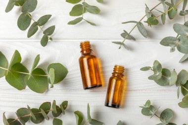 Okaliptüs, ahşap kaplamalı yeşil okaliptüs yapraklı cam bir şişede gerekli yağdır. Aromaterapi konsepti. Spa mı? Kozmetik ve vücut bakımı için doğal organik malzemeler.