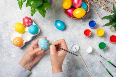 Kadınlar paskalya yumurtalarını mutfak ahşap masasında boyar. Mutlu Paskalya kutlaması kavramları. Farklı şekillerde renkli paskalya yumurtaları..