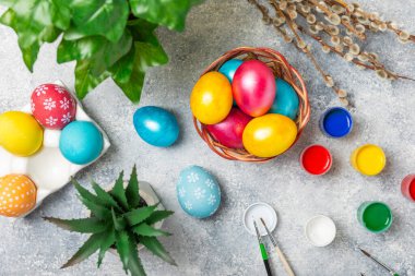 Mutfak masasında paskalya yumurtası resmi. Mutlu Paskalya kutlaması kavramı. Farklı şekillerde renkli paskalya yumurtaları. Resimler, tatiller için yumurta boyama süslemeleri.
