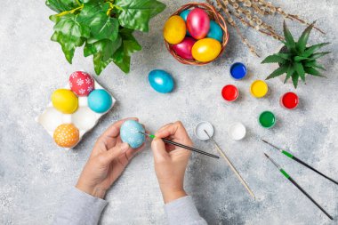 Kadınlar paskalya yumurtalarını mutfak ahşap masasında boyar. Mutlu Paskalya kutlaması kavramları. Farklı şekillerde renkli paskalya yumurtaları..