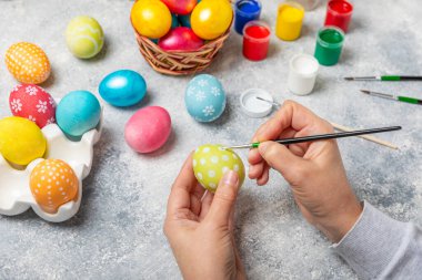 Kadınlar paskalya yumurtalarını mutfak ahşap masasında boyar. Mutlu Paskalya kutlaması kavramları. Farklı şekillerde renkli paskalya yumurtaları..