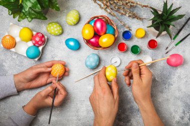 Aile, mutfak masasına Paskalya yumurtası boyamış. Mutlu Paskalya kutlaması kavramları. Farklı şekillerde renkli paskalya yumurtaları..